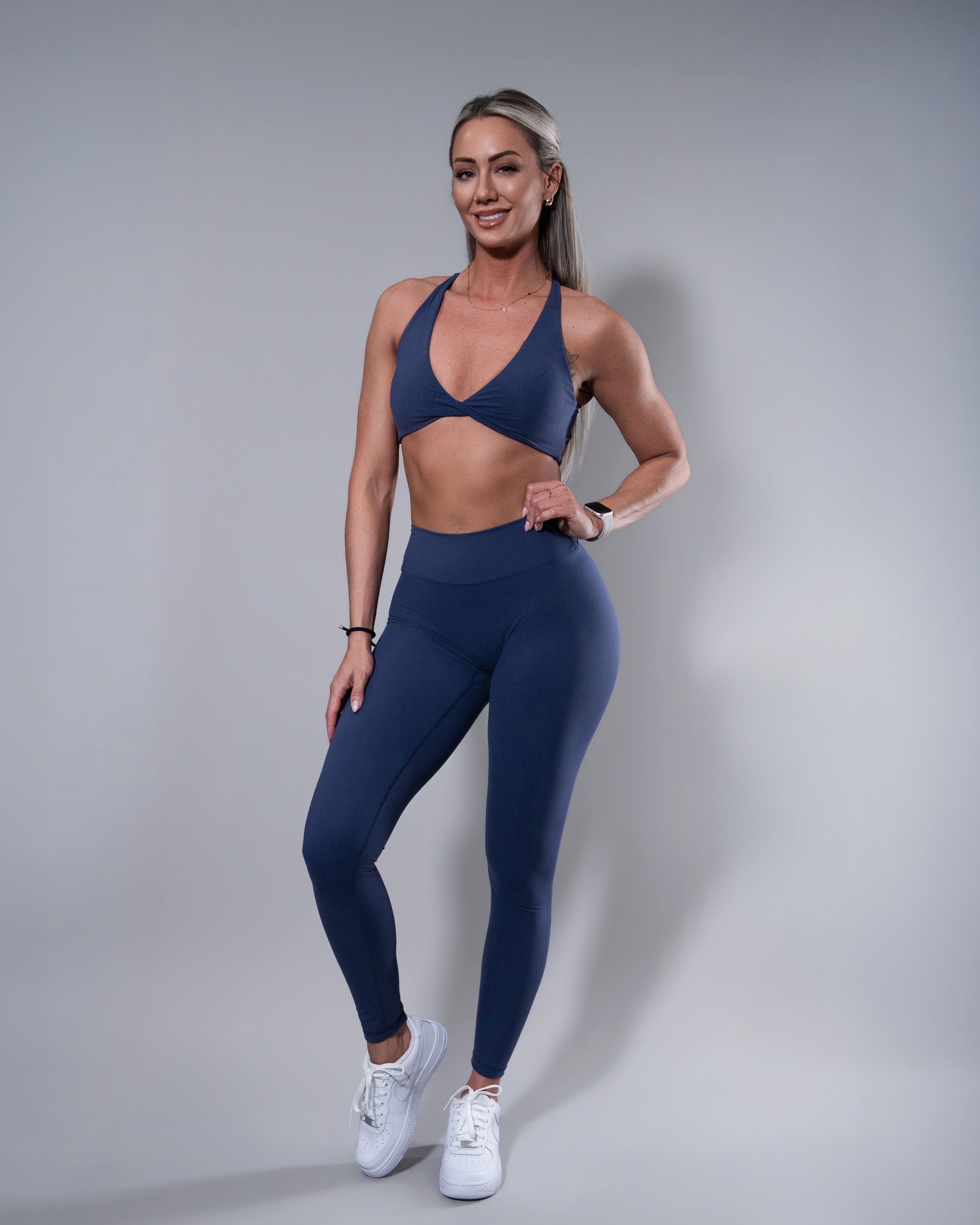 Allure V-Back Leggings in navy blue, front view paired with navy twist sports bra