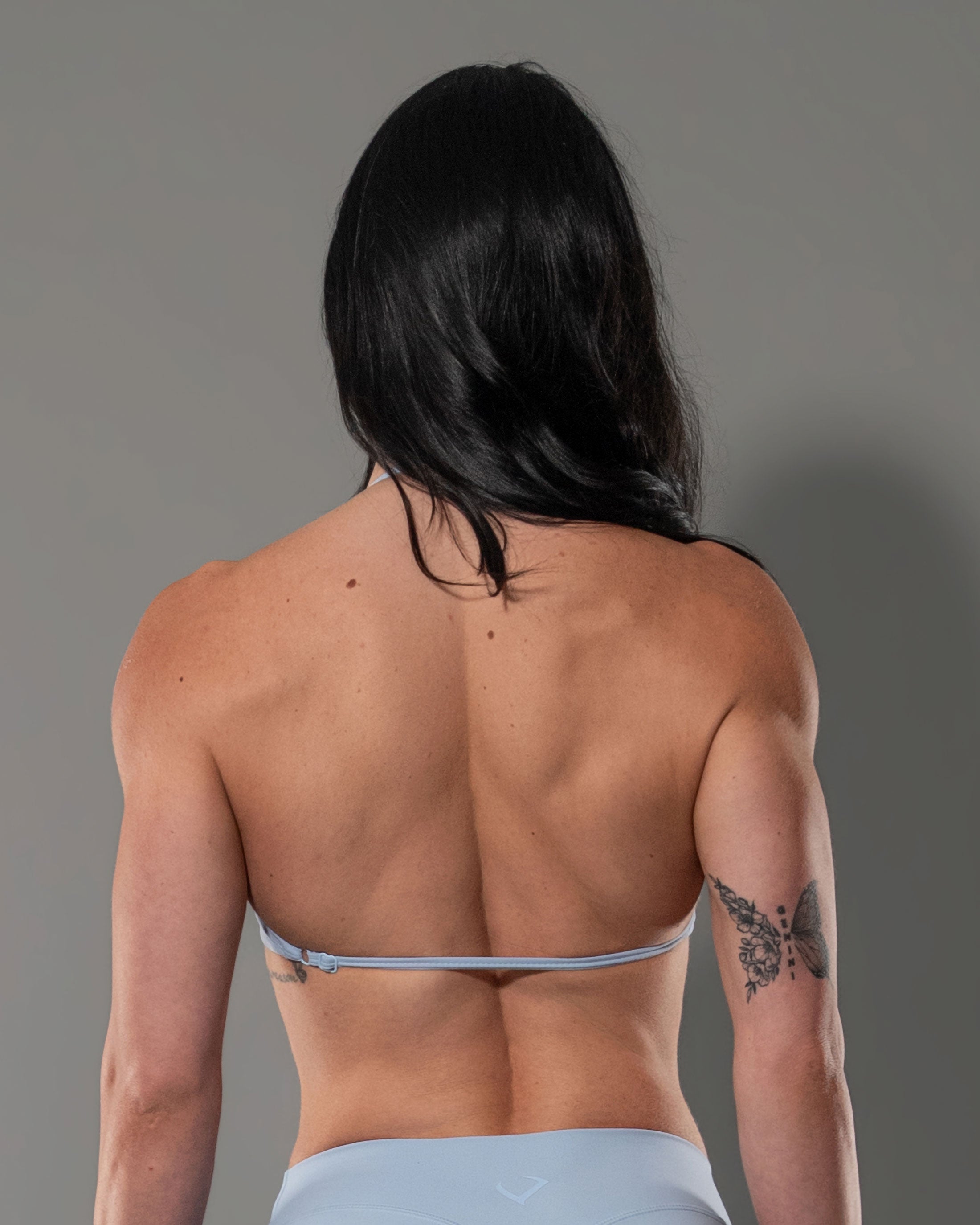 Model wearing the Sky Blue Tempt Halter, open back detail with adjustable straps