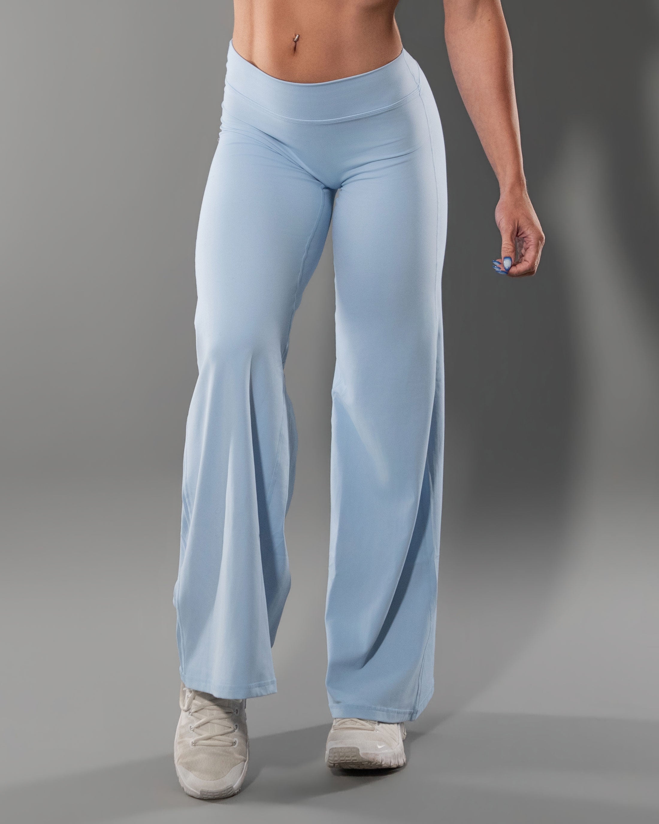 Woman wearing the Tempt Flares in Sky Blue, front view of the high waisted flare leggings